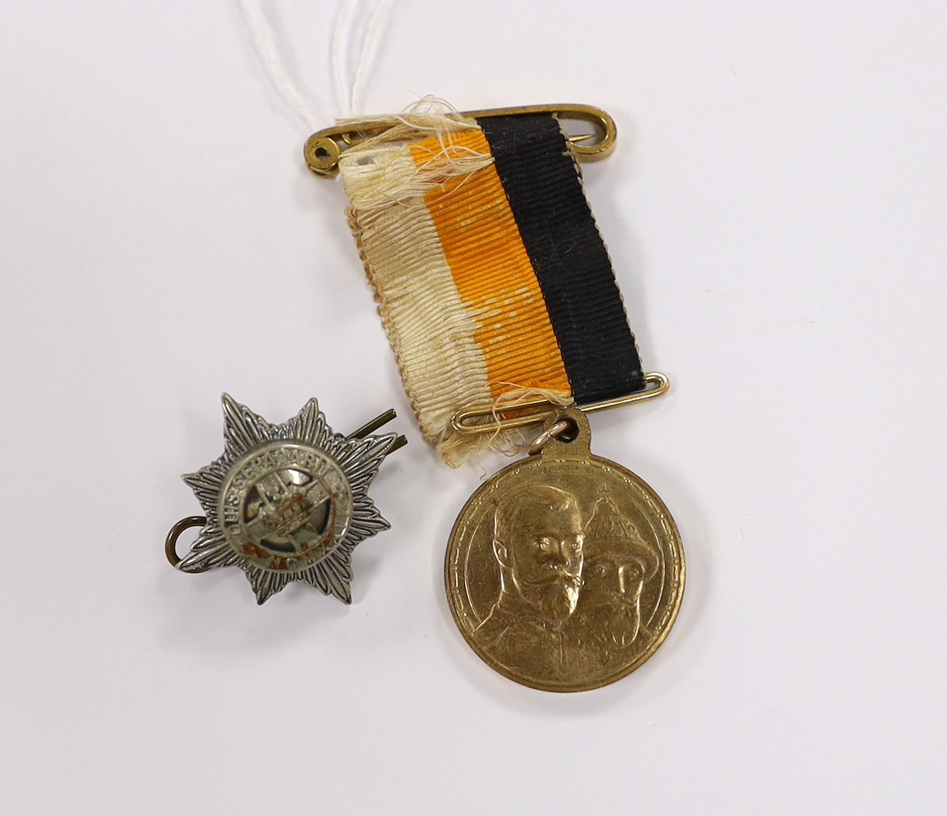 A Russian commemorative House of Romanov medal and a regimental clasp, 1922